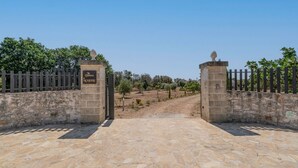 A stone pathway leading to a gated entrance with a sign reading 'La Dintora A Nobile.' - La Dimora di Nobile by Rentbeat (Carovigno)