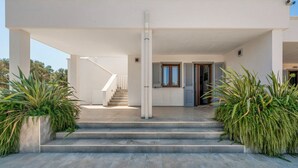 A modern building with a staircase leading to a door, surrounded by greenery. - La Dimora di Nobile by Rentbeat (Carovigno)
