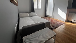 A modern bedroom with a bed, a small table, and a TV. - Pisu Apartments (appart.Orsolina)  (Quartucciu)