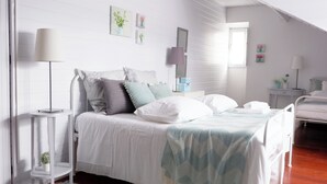 A bedroom with a bed, bedside tables, a lamp, and a window.