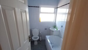 Ein Badezimmer mit Toilette, Waschbecken und Badewanne.