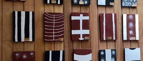 A wall with 16 square artworks arranged in a grid pattern.