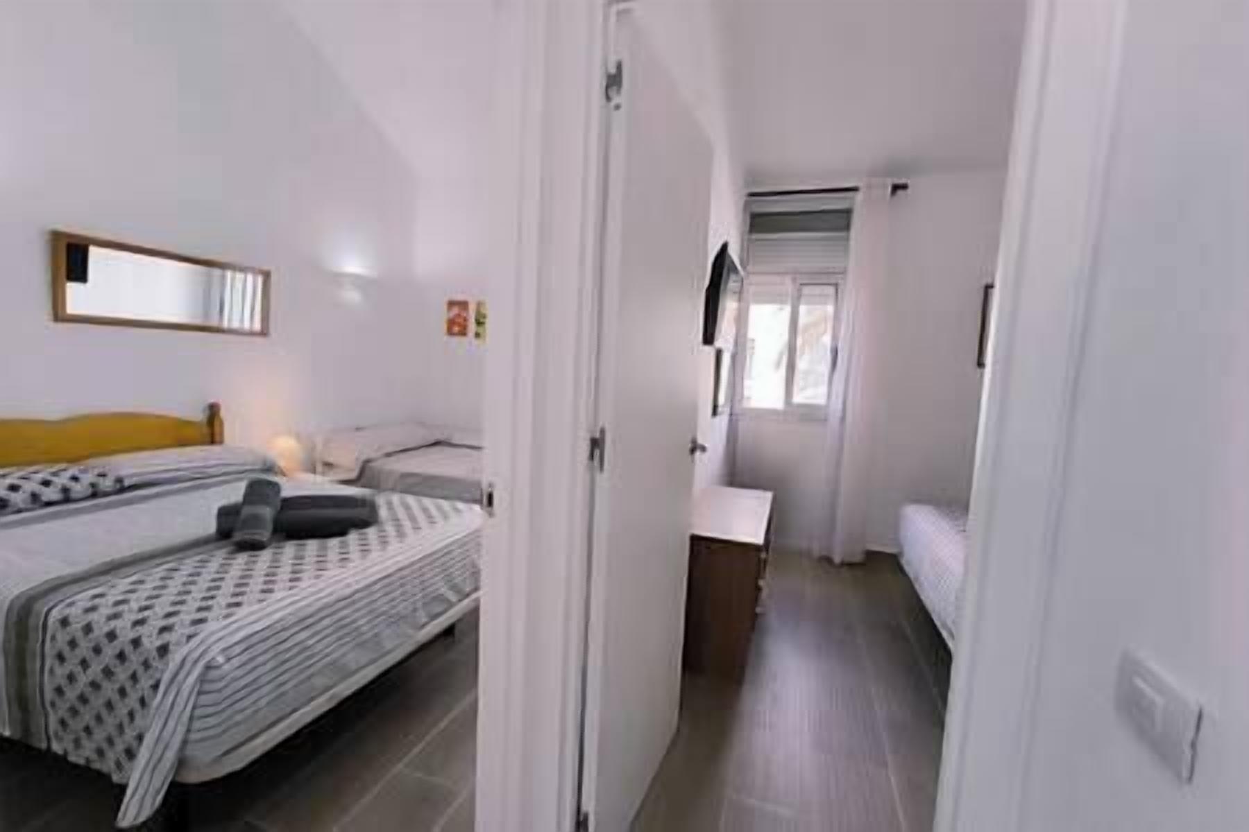 Ein Hotelzimmer mit Bett, Nachttisch, Spiegel und Fenster.