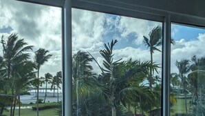 Blick durch ein Fenster auf einen wolkenlosen Himmel und Palmen.