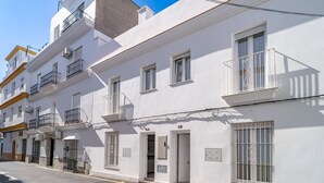 A white building with multiple balconies and windows, a street in front, and a clear sky. - Beautiful home in Conil de la Frontera (Conil de la Frontera)