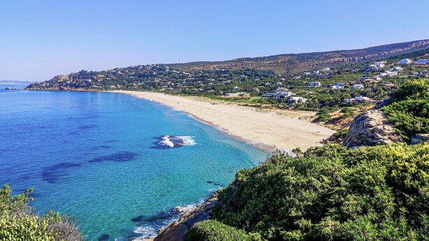 A coastal landscape with a clear blue sea, sandy beach, and a hillside with scattered buildings. - Beautiful home in Conil de la Frontera (Conil de la Frontera)