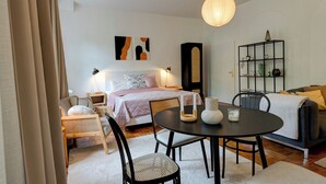Una camera da letto moderna con un letto, comodini, un tavolo rotondo e una libreria.