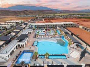 Ein Resort mit mehreren Schwimmbecken, einem Wasserpark und Blick auf Berge.