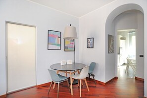 Un coin repas avec une table ronde, quatre chaises et une lampe.