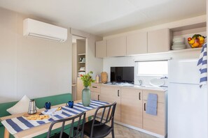 A compact kitchen with a dining area, a built-in stove, and a refrigerator.