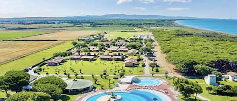 A resort with multiple swimming pools, a golf course, and a beach view.