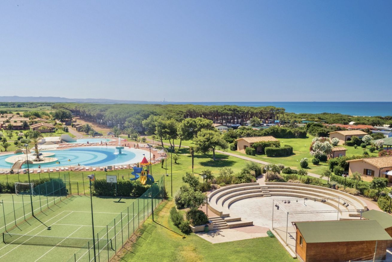 A resort with a swimming pool, tennis courts, and a large amphitheater.