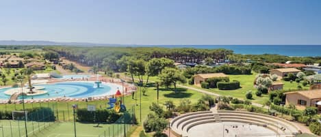 A resort with a swimming pool, tennis courts, and a large amphitheater.