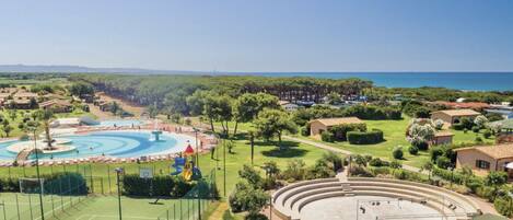 A resort with a swimming pool, tennis courts, and a large amphitheater.