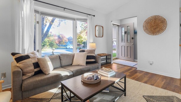 A living room with a sofa, coffee table, and a view of the outdoors.