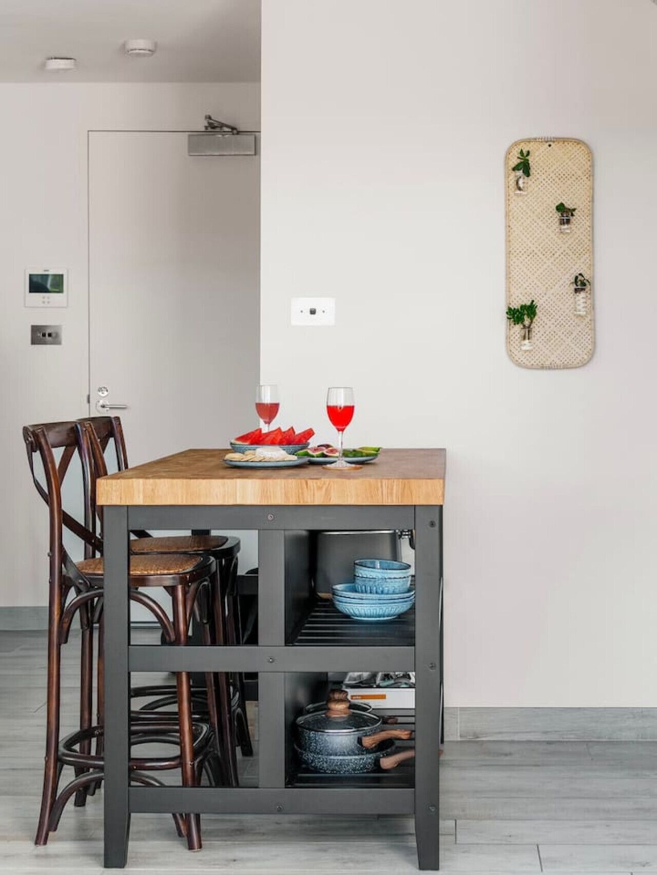 Een eetgedeelte met een houten tafel, twee stoelen en een wandlamp.