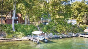 Une propriété au bord du lac, dotée d’un quai, d’un abri à bateaux et d’un escalier menant à une terrasse.