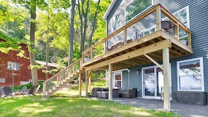 A two-story house with a wooden deck and a staircase leading to a balcony. - Lone Retreat Lake House: New Build + Close to Ithaca (Interlaken)
