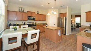 Une cuisine moderne avec des meubles en bois, des appareils en acier inoxydable et un îlot central.