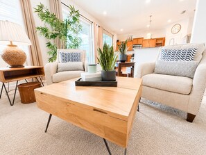 A modern living room with a sofa, coffee table, and a side table with a lamp.