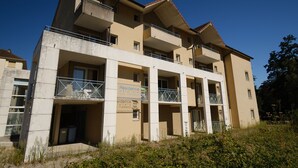 Un hotel de varios pisos con balcones, un letrero que indica que es un hotel residencia, y un cielo azul despejado al fondo.