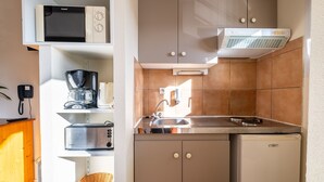 A compact kitchen with a microwave, toaster, and refrigerator.