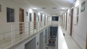 A long corridor with multiple doors, a central walkway, and a railing overlooking a lower level. - Hotel VZ GYN (Goiânia)