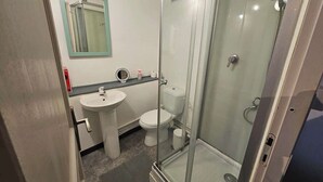 Ein Badezimmer mit Duschkabine, Waschbecken und Toilette.