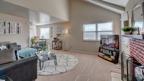A living room with a sofa, coffee table, TV, and a fireplace.
