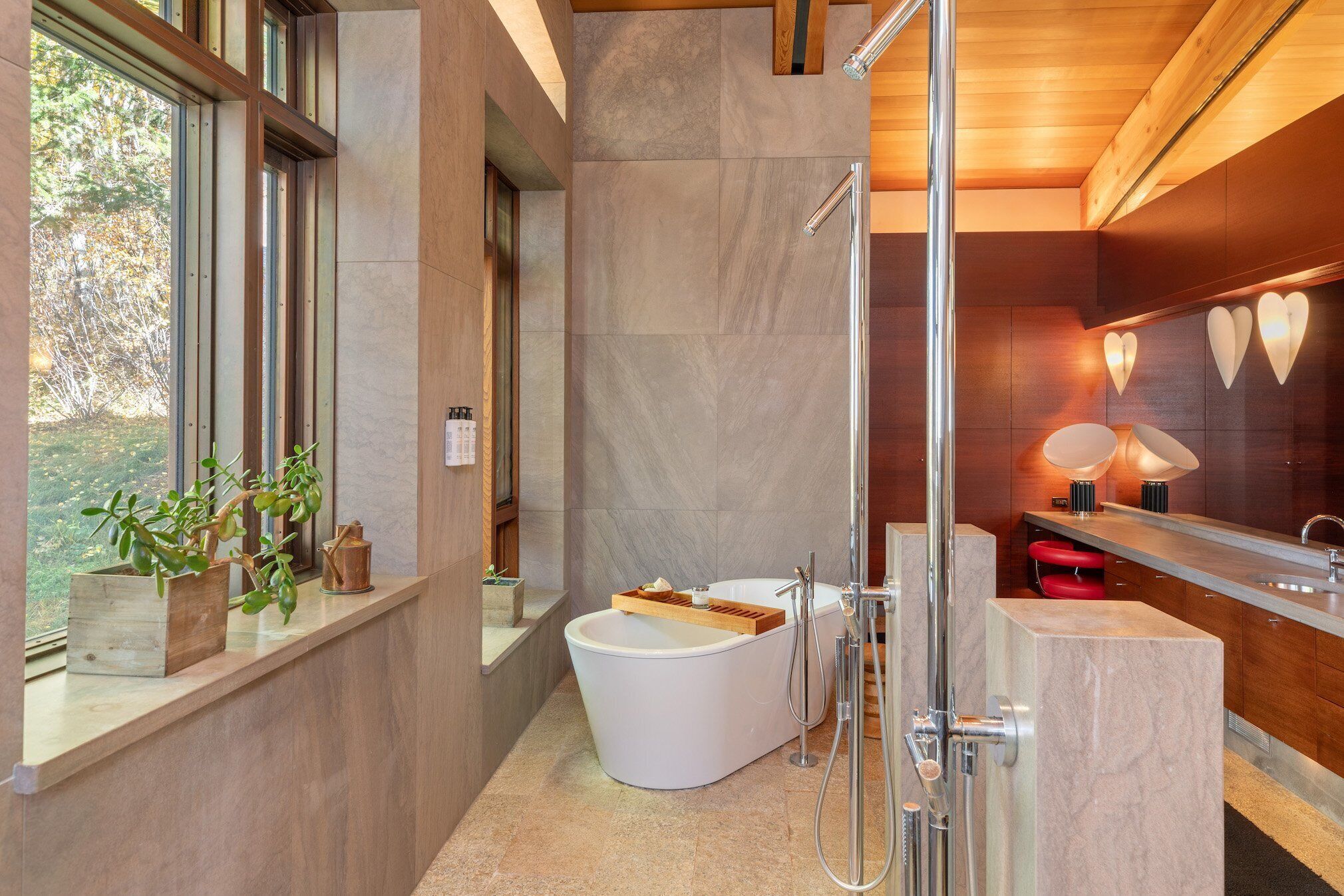 A modern bathroom with a freestanding bathtub, a glass shower enclosure, and a vanity with a mirror.