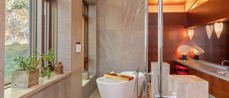 A modern bathroom with a freestanding bathtub, a glass shower enclosure, and a vanity with a mirror.