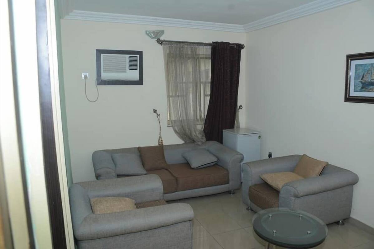 A living room with two sofas, a small table, and a window with curtains.