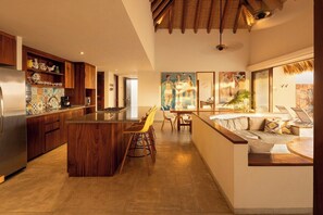 Een moderne keuken met houten kastjes, een centraal eiland en barstoelen.