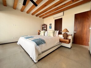 A bedroom with a bed, bedside table, lamp, and wardrobe.