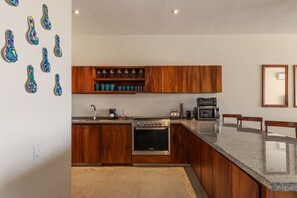 Une cuisine moderne avec des meubles en bois, un plan de travail en granit et un four encastré.