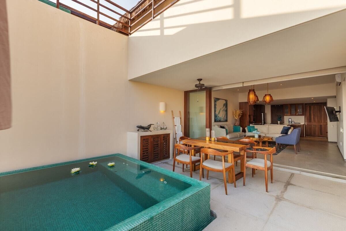 A modern interior with a swimming pool, dining area, and living space.