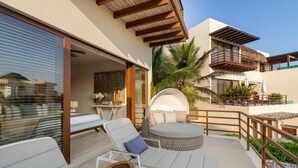 A modern outdoor lounge area with a circular seating arrangement, a dining table, and a thatched-roof structure. - Elegant 2BR Villa I Ocean View + Artful Style (Zihuatanejo)
