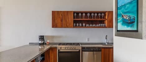A modern kitchen with wooden cabinets, a built-in wine rack, a stove, and a dishwasher.