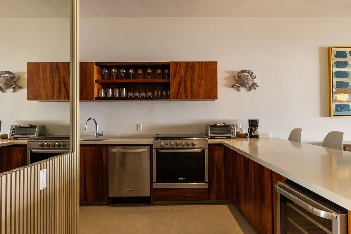 Una cocina moderna con armarios de madera, una cava empotrada, electrodomésticos de acero inoxidable y una isla grande.