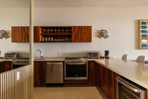 A modern kitchen with wooden cabinets, a built-in wine rack, stainless steel appliances, and a large island.