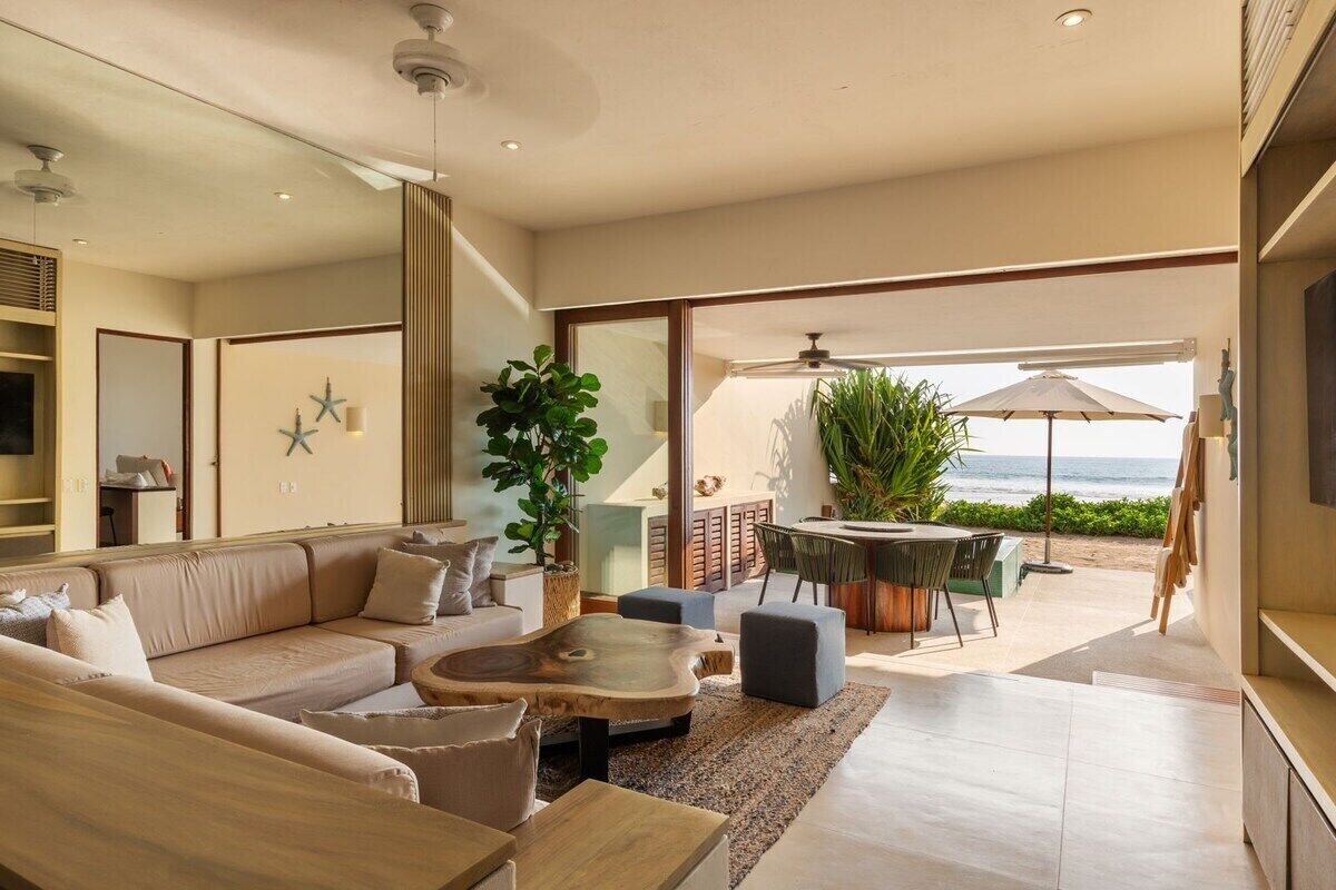 A modern living room with a sofa, coffee table, and dining area.