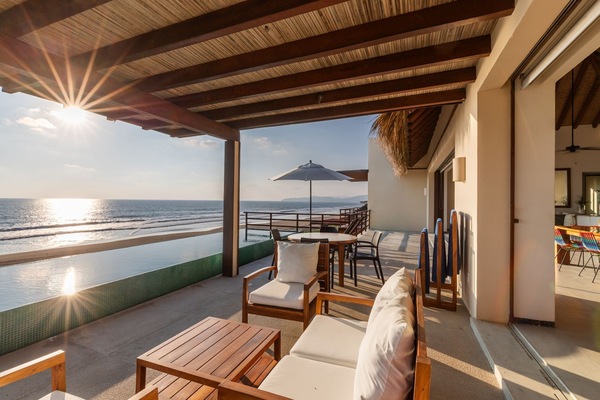 Enjoy peaceful evenings in this cozy outdoor seating area, overlooking the beach and capturing breathtaking sunset views.