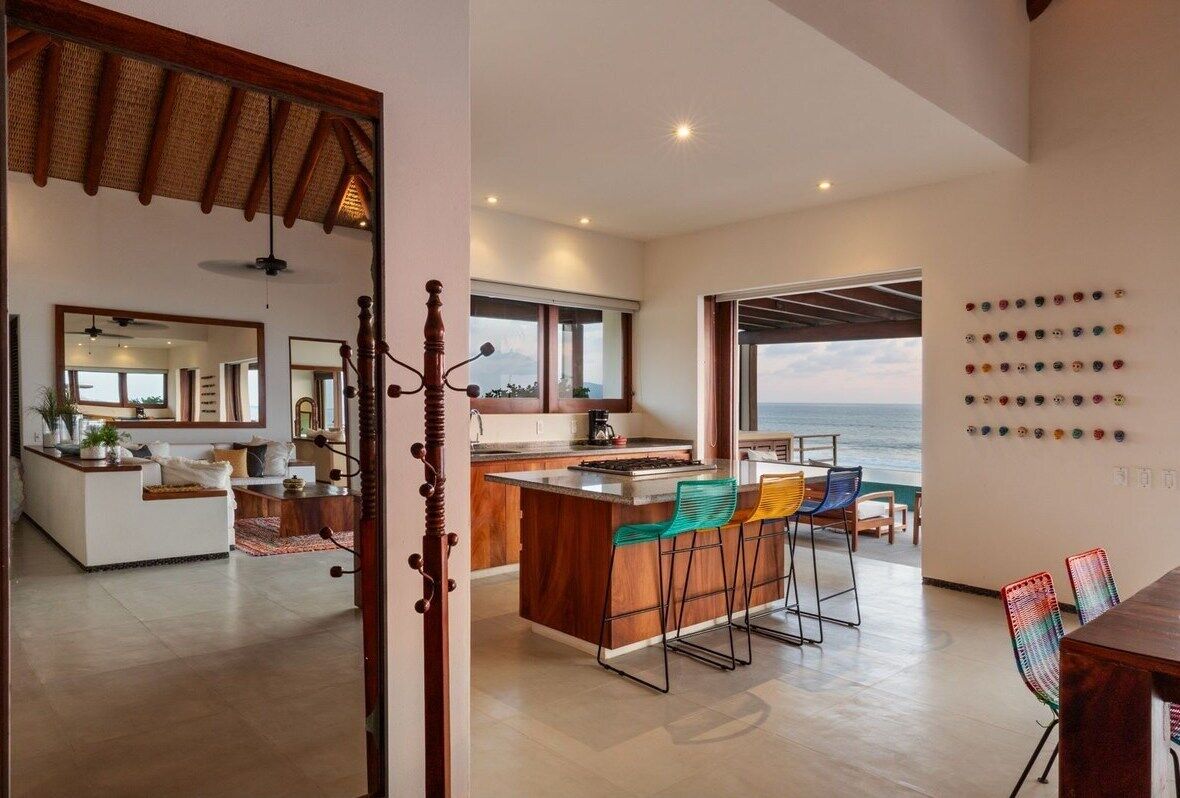 A modern kitchen featuring rustic wood finishes, bar seating, and an open-air design perfect for entertaining.