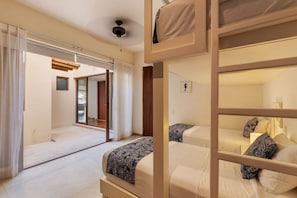 A hotel room with two beds, a ceiling fan, and a view through a window. - 3BR Beachfront Villa • Private Terrace + Pool (Zihuatanejo)