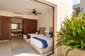 A bedroom with two beds, a ceiling fan, a large mirror, and a potted plant. - 3BR Ocean Penthouse I Private Pool + Sunset Deck (Zihuatanejo)