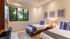 Ein Hotelzimmer mit zwei Betten, einem großen Fenster und Blick ins Grüne sowie Wandbildern.