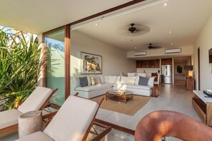 A modern living room with a sofa set, a coffee table, and a dining area with a table and chairs. - 3BR Beachfront Villa • Pool, Terrace • Sleeps 6 (Zihuatanejo)