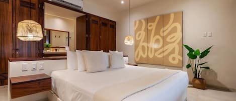 A bedroom with a large bed, wooden wardrobe, bedside table, and a wall-mounted air conditioner.