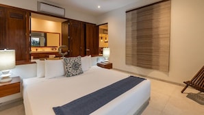 A hotel room with a large bed, wooden wardrobe, a mirror, bedside lamps, and a view of the outside. - Zihua 3BR Villa • Oceanfront + Sleeps 6 + Family (Zihuatanejo)