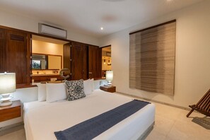 Une chambre d’hôtel avec un grand lit, une armoire en bois, un miroir, des lampes de chevet et une vue sur l’extérieur.